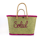 panier artisanal aravola luxe GM brodé soleil fuchsia en fibres naturelles, tressage traditionnel en aravoula dimension 50x 20x 32 avec finition brodée et fermeture bouton, idéal pour la plage, le marché et la ville.