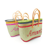 Pile panier artisanal brodé amour GM en fibres naturelles, tressage traditionnel en aravoula dimensions 50x 20x 32 avec finition brodée et fermeture bouton, idéal pour la plage, le marché et la ville.