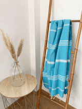 fouta plate traditionnelle kolora turquoise 100x200 cm, coton 190 g/m², absorbante, légère et peu encombrante pour la plage ou la maison. se transforme en paréo.